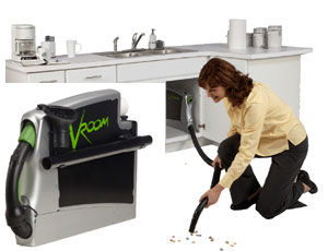 Woman Using Gary's Vacuflo Central Vacuum Solutions for Cabinets with the Product Displaying Next to Her - Hose Management & Quick Clean-Up 