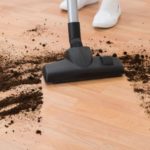 Vacuum head for hard floors vacuuming up black dirt.