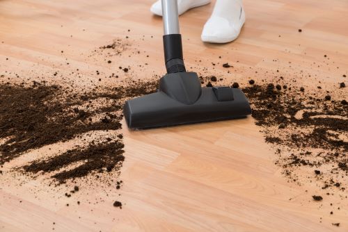 Vacuum head for hard floors vacuuming up black dirt.