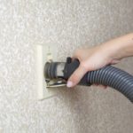 Central vacuum hose being plugged into inlet.