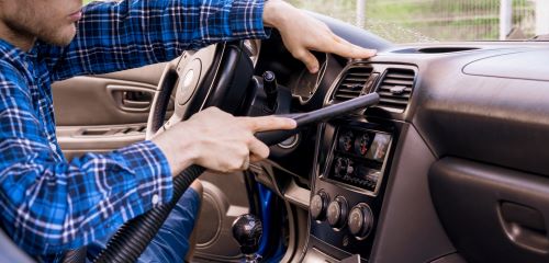 Man vacuuming car with vacuum garage accessories.
